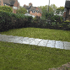 Turfed lawn with path through leading to the house rejuvenating the front garden of this home
